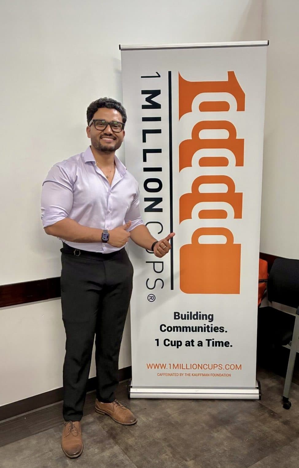 Manikanta beside the 1 Million Cups banner