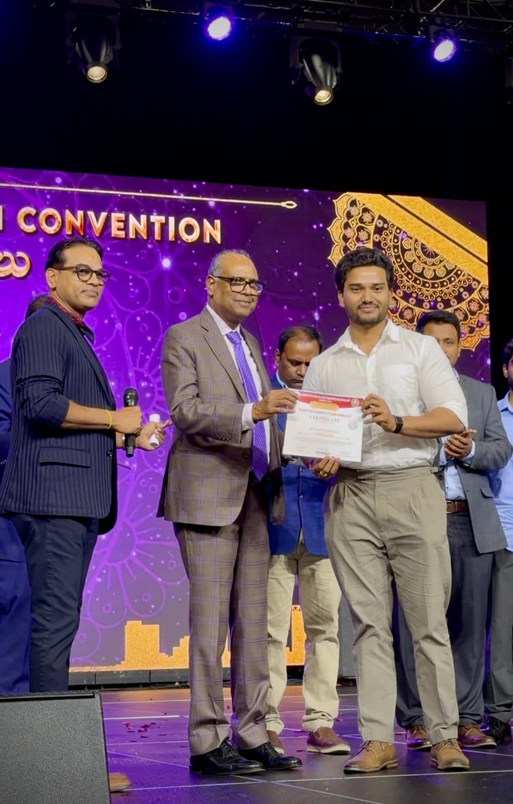 Manikanta receiving a top 5 certificate on stage at the ATA Convention