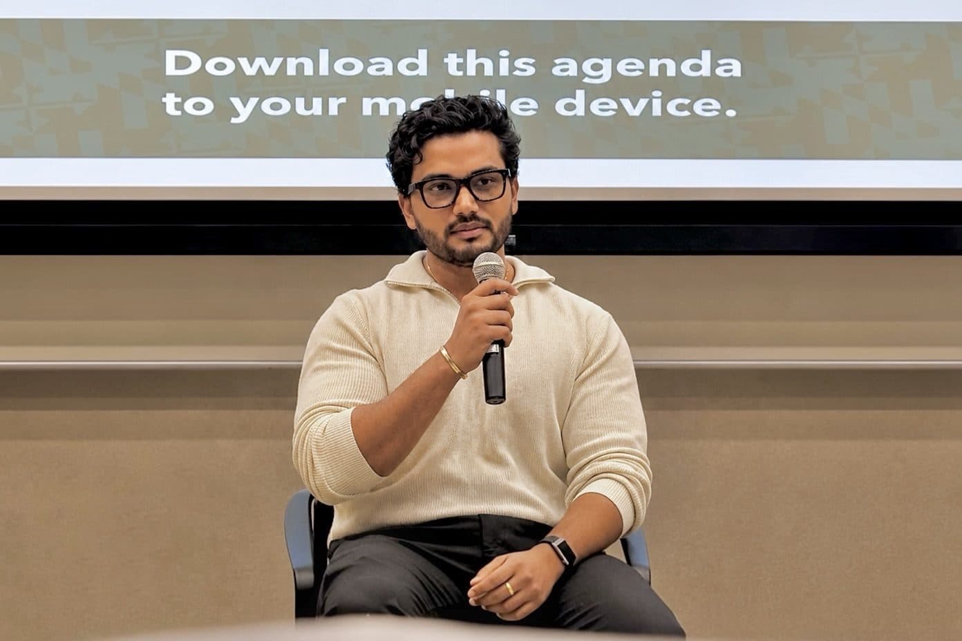 Manikanta speaking into a microphone on the orientation panel